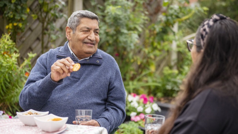 Two people having a cup of tea in their garden