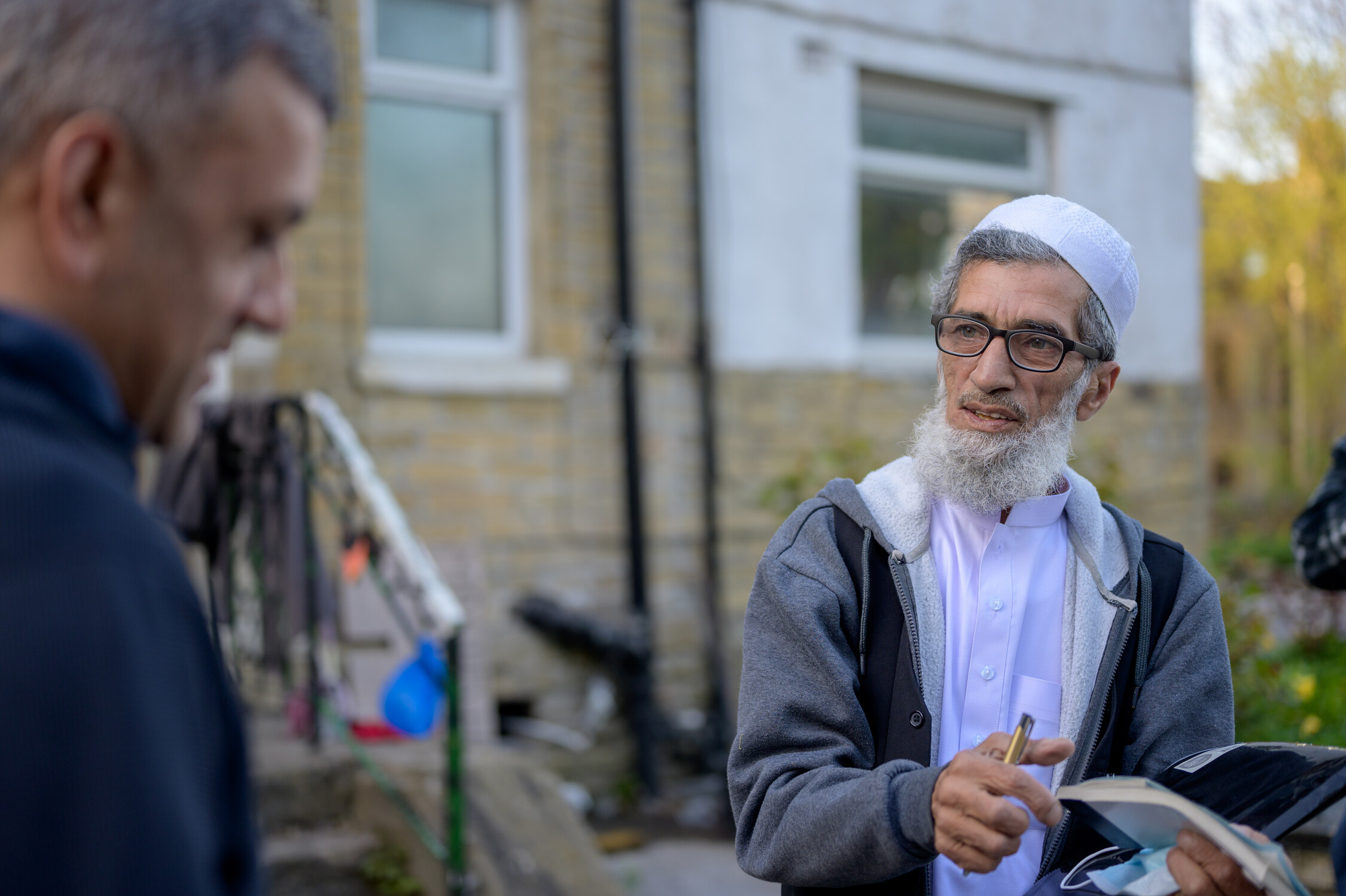 An older man holding a notebook