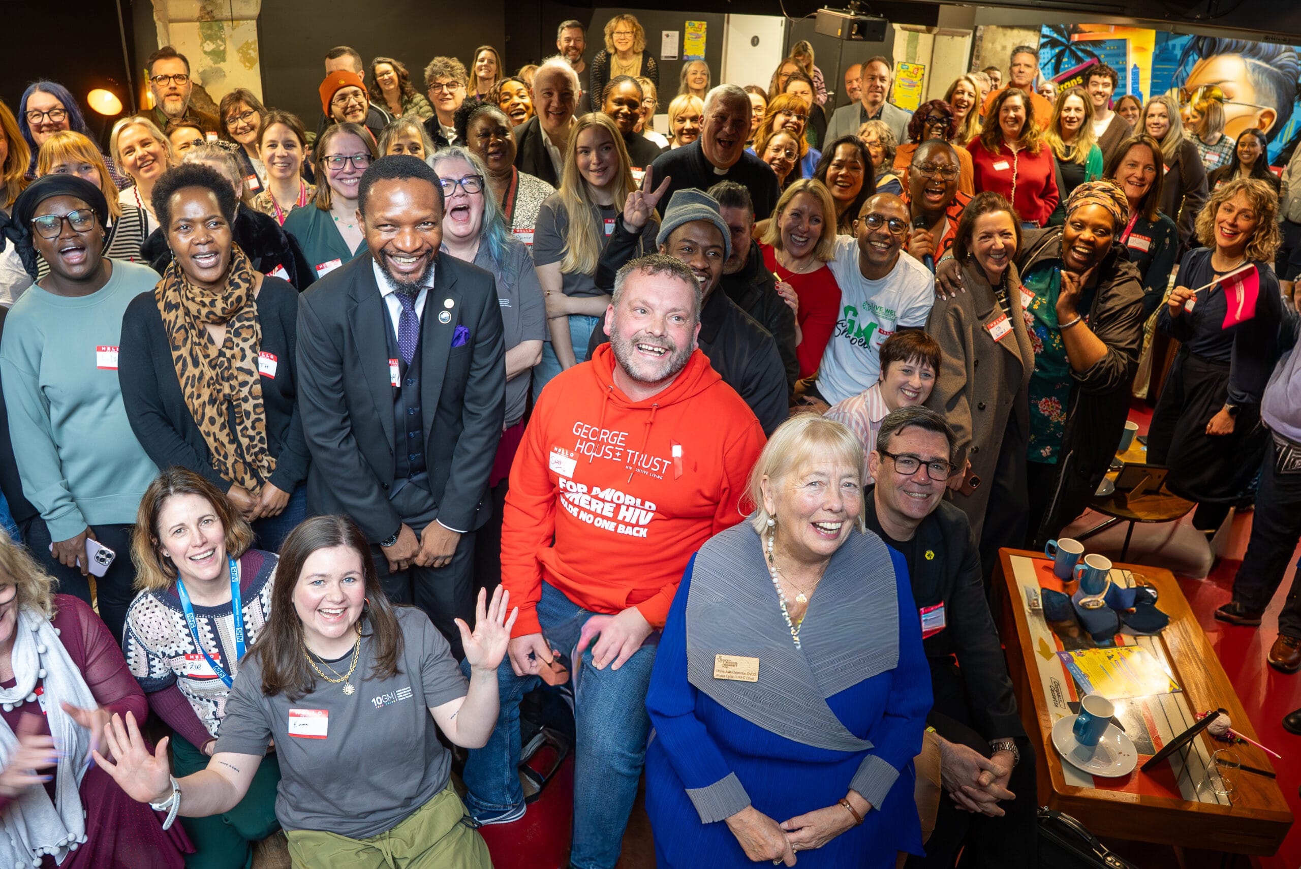 A photograph of attendees at the Live Well Spaces of Hope and Connection launch. Everyone is smiling at the camera.