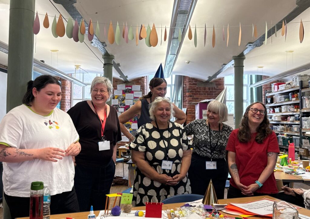 Participants taking part in a collaborative workshop activity, sharing ideas and discussing learning in a community space
