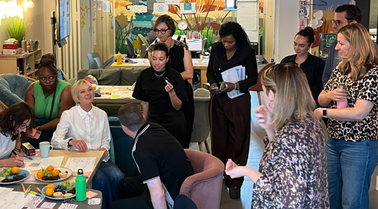 Participants taking part in a collaborative workshop activity, sharing ideas and discussing learning in a community space